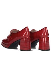 Rode lakleren schoenen met een ronde neus, decoratieve band en blokhak met een subtiele gestreepte structuur. Gladde textuur.