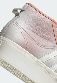 High-top sneaker featuring a gradient leather upper in light pink and gray, white rubber sole, and detailed stitching accents.