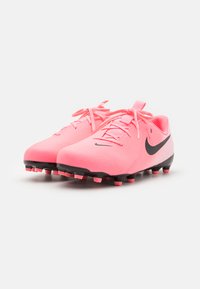 Des crampons de football roses en matériau lisse, avec un swoosh noir sur le côté, des pointes contrastantes noires et roses, et un design élégant à lacets.