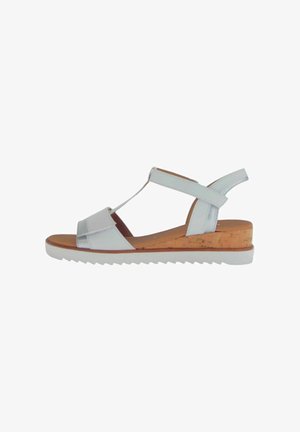 White leather sandal with cork wedge, rubber sole, T-strap design, and adjustable back strap. Smooth texture and minimalist style.