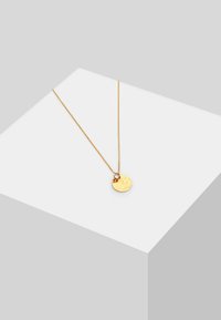 Goldene Halskette mit einem strukturierten runden Anhänger an einer dünnen Kette, mit einer kleinen Schlaufe oben zur Befestigung. Minimalistisches Design.