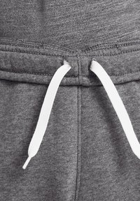 Pantalones deportivos grises con una textura suave, cintura elástica y cordones blancos con puntas de metal para ajustar.