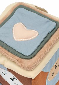Soft fabric cube featuring pastel colors, including blue, green, tan, and brown. Textured accents and a stitched heart detail.