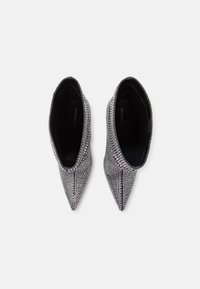 Scarpe argentate con paillettes, punta affilata, superficie strutturata e design elegante, con morbida fodera interna nera.