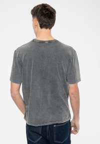Gray cotton T-shirt with a relaxed fit. Features a crew neckline, short sleeves, and a soft, washed texture with minimal stitching details.