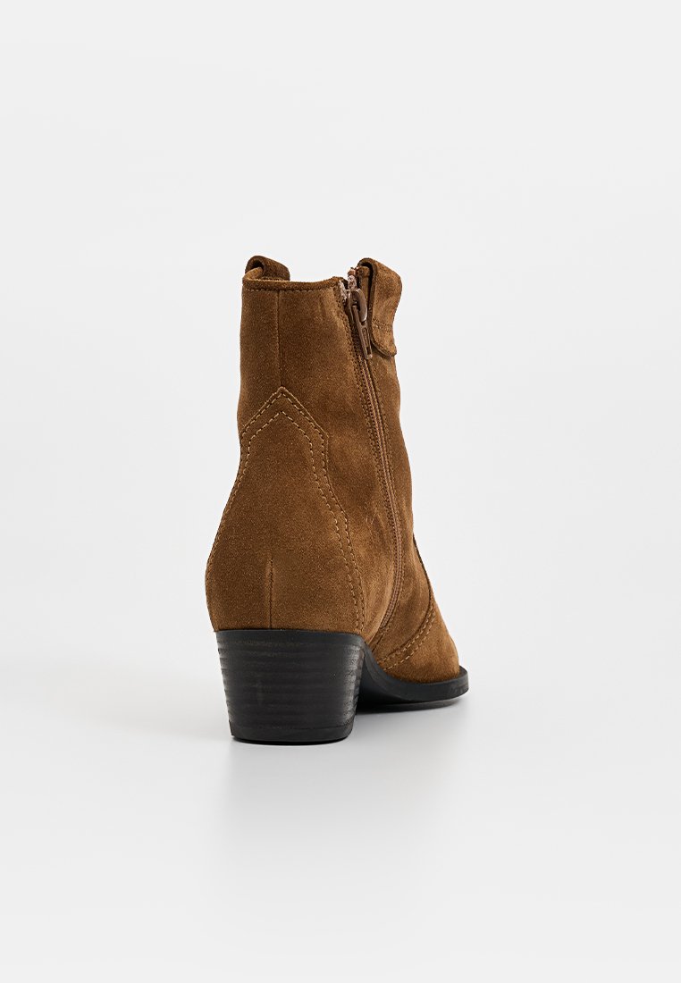 Braune Wildleder Stiefeletten mit einem seitlichen Reißverschluss, Blockabsatz, schrägem Design und dekorativen Nähten im Obermaterial. Flache, glatte Sohle.