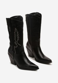 Bottes de cowboy en cuir noir avec un bout pointu, un talon haut et des broderies argentées complexes sur la tige. Fermeture éclair sur le côté.