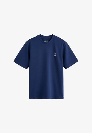 Granatowy t-shirt z krótkim rękawem i okrągłym dekoltem, z małą wyszywaną twarzą Bugs Bunny na lewej piersi.