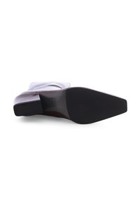 Spitz zulaufender Knöchelboot mit Blockabsatz. Hergestellt aus texturiertem hellbraunem Leder mit einer glatten schwarzen Gummisohle.