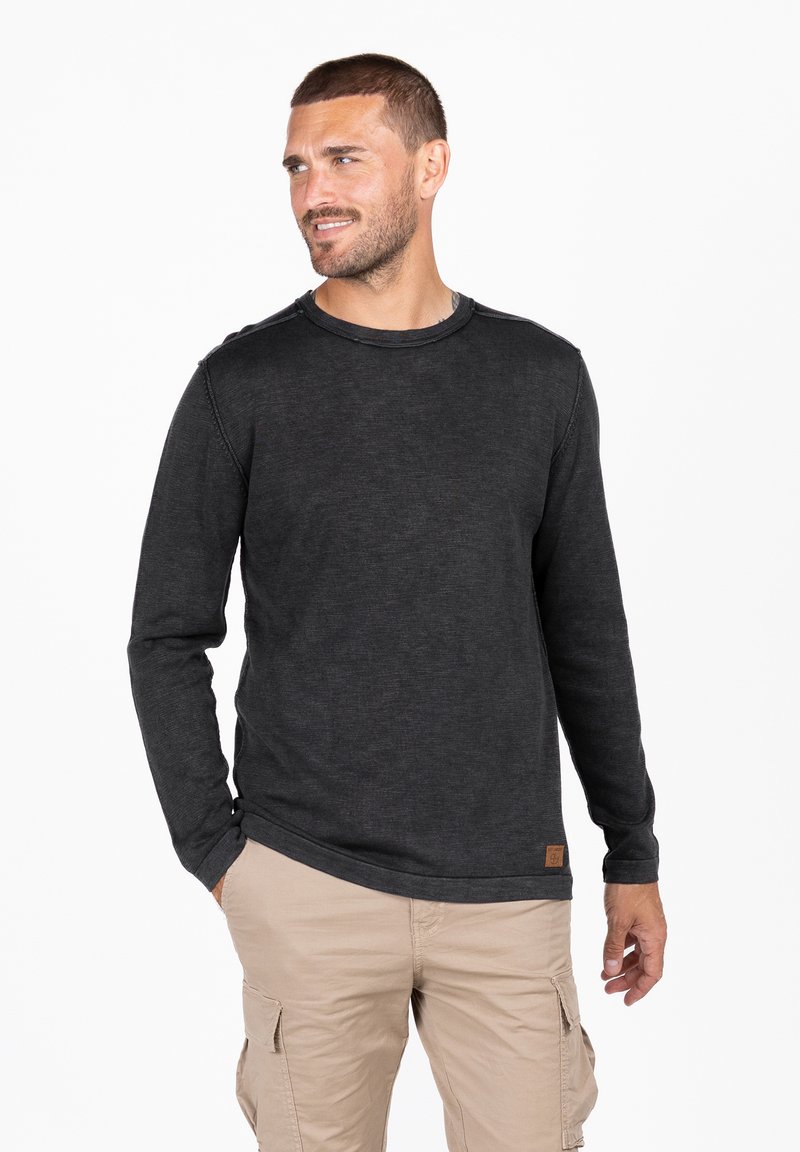 Camisa de manga larga gris oscuro hecha de una mezcla de algodón; presenta un escote redondo, costura sencilla y una pequeña etiqueta de la marca en el dobladillo.