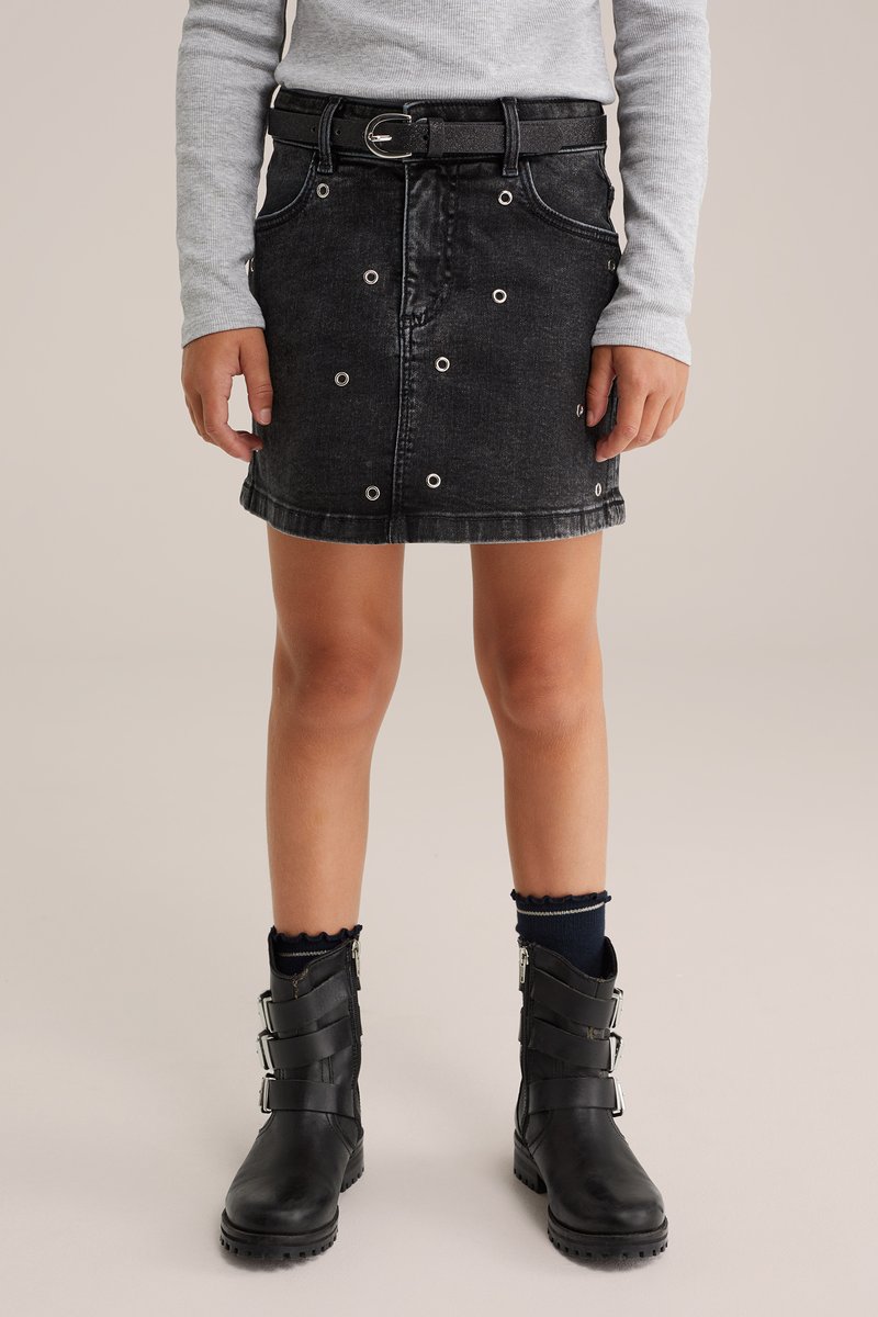Črna jeans mini krila z srebrnimi okrasnimi grometami, ravne rezane, z usnjeno pasom. Ujemajoče se z črnimi gležnjarji in mornarsko modrimi nogavicami.