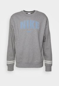 Šedá mikina s modrým logem "NIKE", kulatým výstřihem, dlouhými rukávy a pruhovanými detaily na manžetách. Vyrobena z měkké, texturované látky.