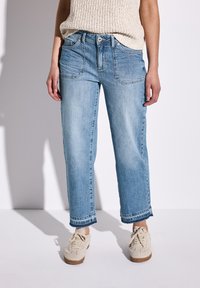 Los jeans de mezclilla de color azul claro cuentan con una cintura alta, pierna recta y dobladillo ligeramente deshilachado. Tienen bolsillos delanteros y un ajuste relajado.