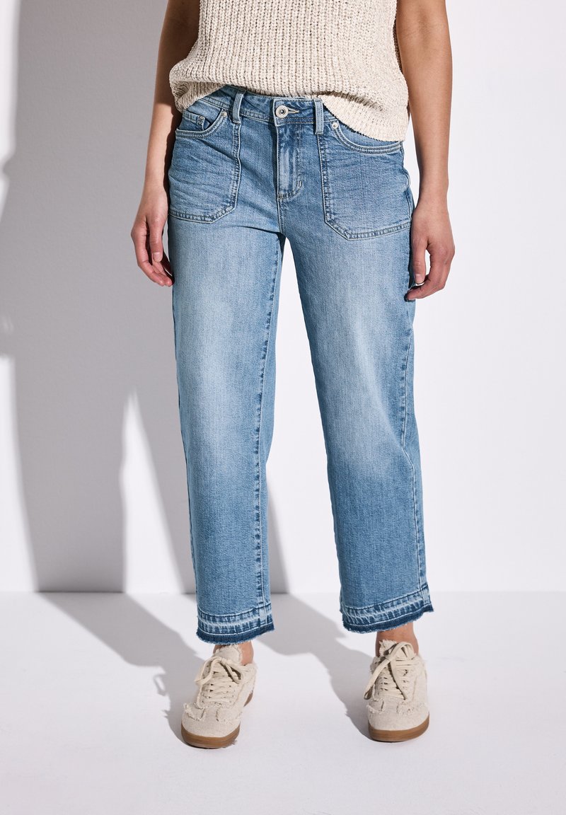 Los jeans de mezclilla de color azul claro cuentan con una cintura alta, pierna recta y dobladillo ligeramente deshilachado. Tienen bolsillos delanteros y un ajuste relajado.