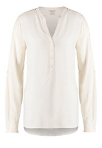 Blouse à manches longues de couleur crème avec col en V, patte de boutonnage et tissu subtilement texturé. Design épuré avec un tombé doux.