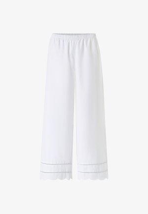 Białe spodnie o szerokich nogawkach z elastycznym pasem i falowanym obrzeżem, ozdobione dwoma rzędami haftu ażurowego.