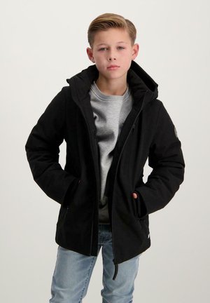 Schwarze Kapuzenjacke mit einem Frontreißverschluss, zwei Seitentaschen und gerippten Bündchen; getragen über einem grauen T-Shirt und blauen Jeans.