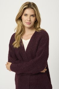 Knit cardigan in deep purple, featuring a textured, chunky pattern and wide sleeves. Open front design with a v-neckline and soft fabric.