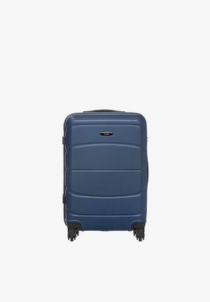 Twarda walizka w ciemnoniebieskim kolorze, wyposażona w cztery obrotowe kółka i górny uchwyt, stojąca pionowo na białym tle.