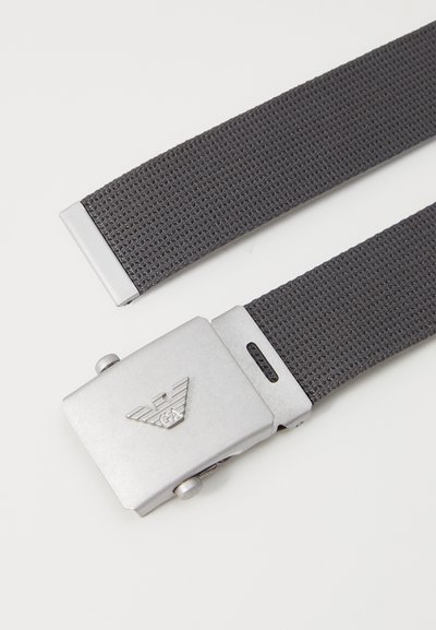 Gray woven belt with a textured fabric and a silver metal buckle featuring an embossed logo and a push-button release mechanism.