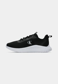 Sapatilha atlética preta com sola branca, design com atacadores, logótipo "cK" da Calvin Klein na lateral, e abas de puxar no calcanhar e na língua.