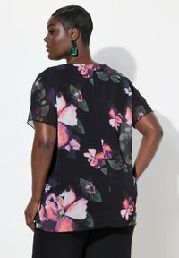 Blusa floreale nera, caratterizzata da fiori vivaci in rosa e viola. Maniche corte e vestibilità morbida. Tessuto liscio e leggero.