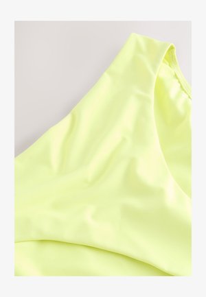 Neongul sports-bh med blødt, elastisk stof. Designet har en bred skulderrem og en sømløs, formet pasform.