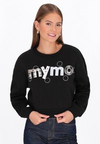Fekete pulóver, amelyen a „mymo” felirat szerepel különböző mintákban és színekben. Bordás mandzsetták és szegély, puha anyagtextúra, laza szabás.