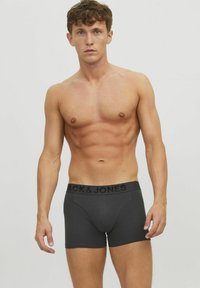Boxer briefs para hombre en negro y gris con una cintura con logo, diseño ajustado y tela suave, que destaca por su ajuste ceñido y cómodo.