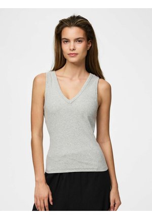 Kobieta z długimi brązowymi włosami nosi jasnoszary bezrękawnik z dekoltem w serek i czarne spodnie na jednolitym białym tle.