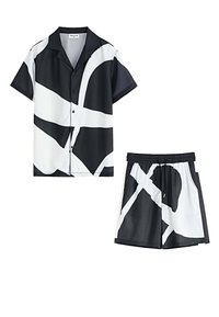 Chemise à manches courtes noire et blanche et shorts assortis, présentant des motifs abstraits, un tissu lisse et une ceinture élastique sur les shorts.