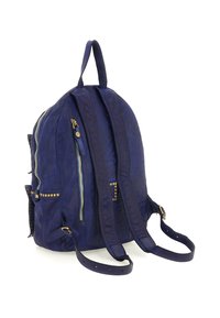 Zaino in pelle blu navy con spallacci regolabili, dettagli in zip dorati e piccole borchie dorate lungo i lati e i punti di attacco degli spallacci.