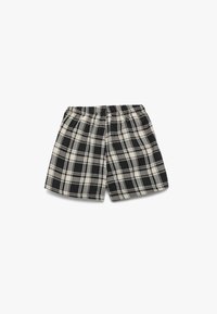 Shorts à carreaux noir et blanc avec une taille élastique, fabriqués en tissu doux. Présente un motif à carreaux avec des tailles de carrés variables.