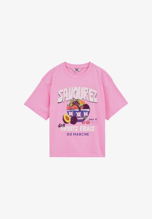 Lyserød T-shirt med korte ærmer med en skål friske frugter og fransk tekst, der promoverer friske markedsfrugter.