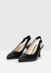 Scarpe con tacco slingback in pelle nera con punta affusolata, tacco di media altezza e dettaglio intrecciato sulla cinghia. Texture liscia, design semplice.