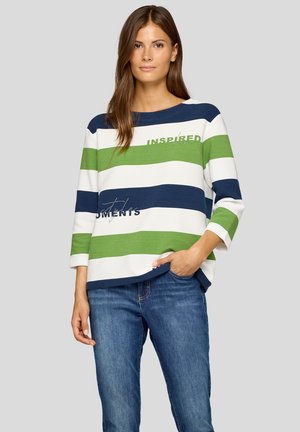Gestreiftes Oberteil in Marineblau, Grün und Weiß, mit einem Bootsausschnitt, drei Viertel Ärmeln und Textverzierungen. Kombiniert mit Jeans.