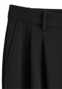 Pantaloni neri a vita alta con passanti per cintura, tasca laterale e dettaglio plissettato sul lato sinistro anteriore.