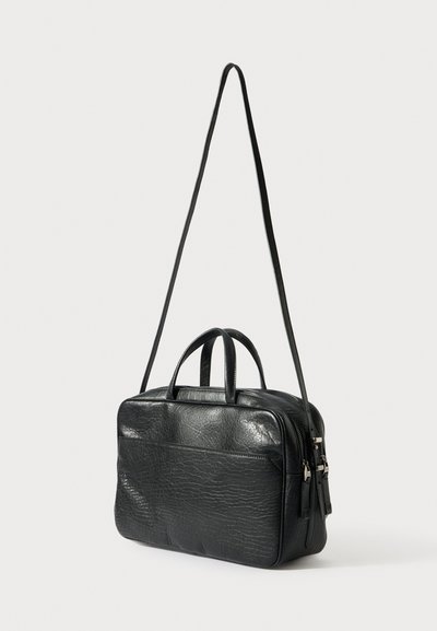 Fekete bőr táska texturált felülettel, két felső fogantyúval és hosszú, állítható pánttal. Cipzáras záródással és külső zsebbel rendelkezik.