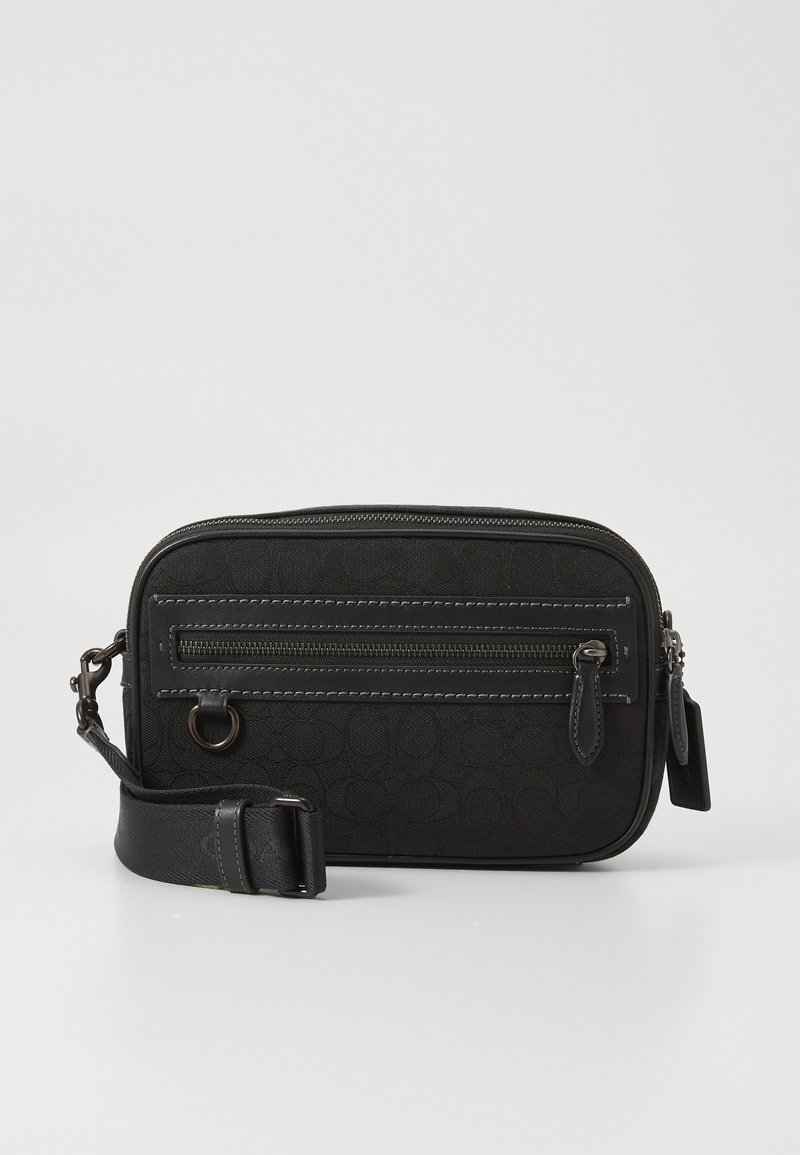 Schwarze Crossbody-Tasche aus strukturiertem synthetischem Material, mit zwei Reißverschlussfächern und einem abnehmbaren Gurt mit verstellbarem Abschnitt.