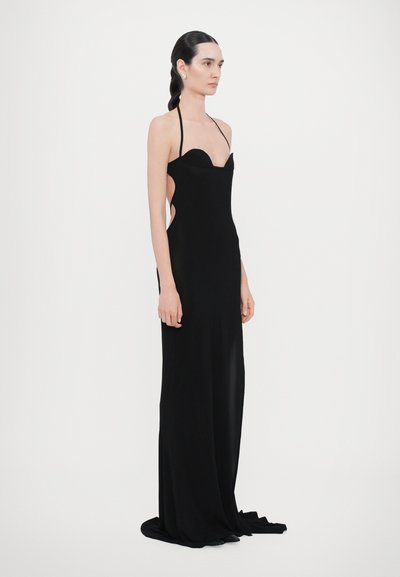 Black evening gown with a fitted silhouette, halter neckline, side cutouts, and delicate floor-length fabric. Smooth texture and minimal design.