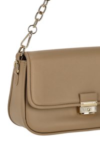 Bolso de mano de cuero beige con textura lisa, diseño tipo sobre, forma rectangular y correa de cadena y herrajes en tono dorado.