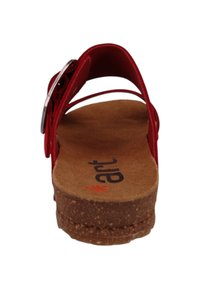 Sandales rouges avec un semelle en liège, des brides étroites et une boucle métallique réglable. La semelle présente une finition texturée pour une bonne adhérence.