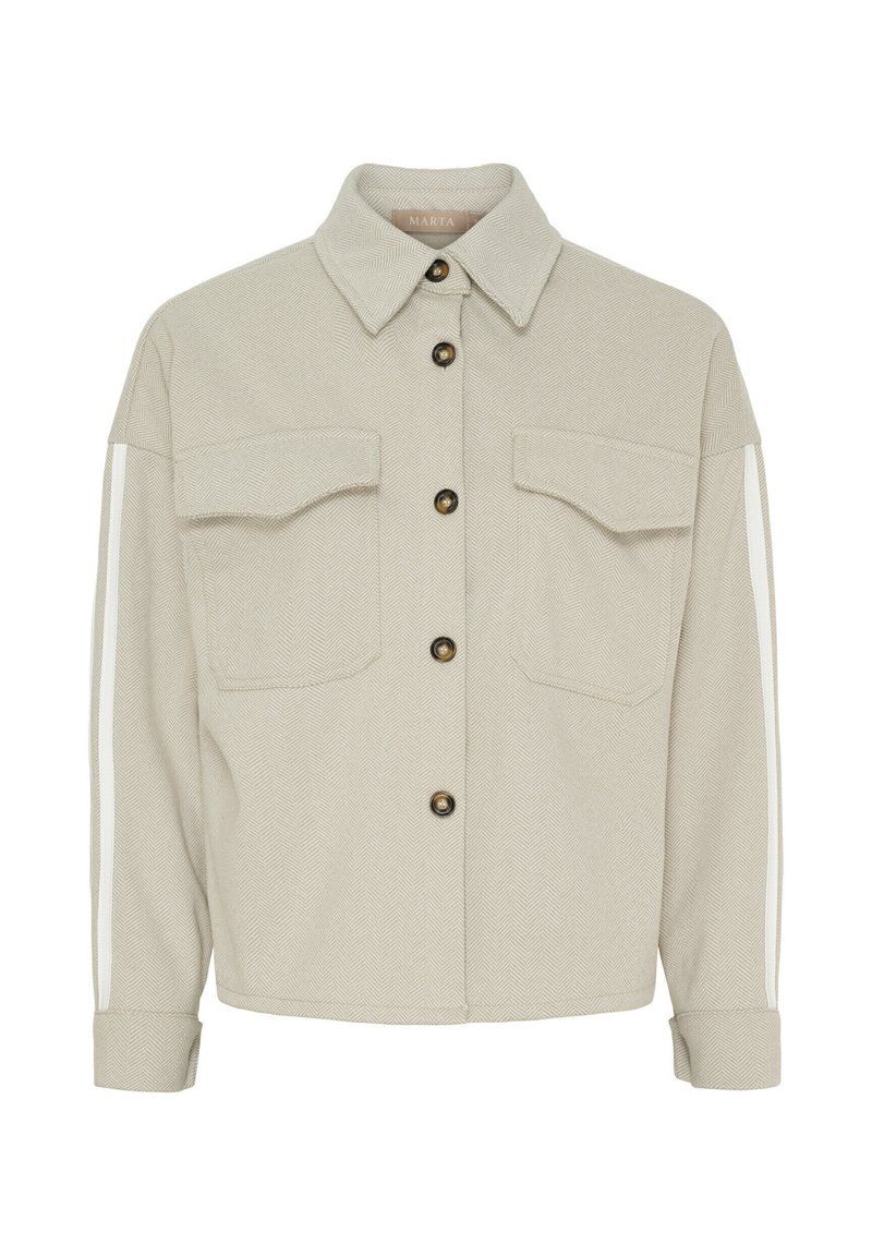 Lys beige hørjakke i fiskebensmønster med spidse krave, to forlommer, brune knapper og hvide lodrette striber langs ærmerne.