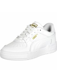 Zapatillas de cuero blanco con puntera perforada, cordones planos y un cuello acolchado. Presentan un logo dorado en la lengüeta y en el lateral. Suela de goma plana.