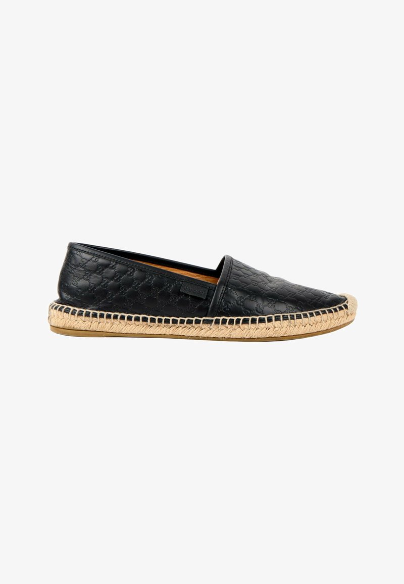 Espadrille en cuir noir à enfiler avec motif embossé, semelle en jute tissée naturelle et semelle en caoutchouc, vue de profil sur fond blanc.
