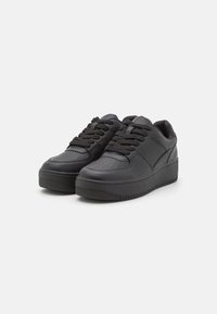 Sneaker neri con tomaia in pelle texturizzata, chiusura con lacci, colletto imbottito e suola in gomma spessa con motivo a righe.