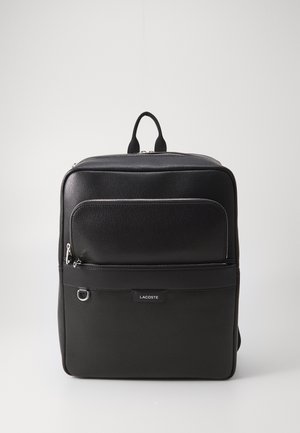 Sac à dos noir texturé avec une poche zippée à l'avant, une poignée supérieure et un logo. Il présente des zips lisses et un design structuré et élégant.