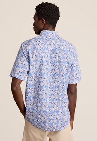 Korte mouwen overhemd in blauw met een wit en paars bladdessin, voorzien van een standaard kraag, zachte stof en een gebogen zoom.