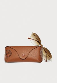 Ray-Ban Sonnenbrillen mit braunen Verlaufslinsen, goldfarbener Metallfassung und Schildpatt-Akzenten, neben einem strukturierten braunen Lederetui.