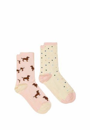 Zwei Paar Knöchelsocken, eines rosa mit braunen Hundemustern, das andere cremefarben mit mehrfarbigen Polka-Dots und rosa Fersen und Zehen.